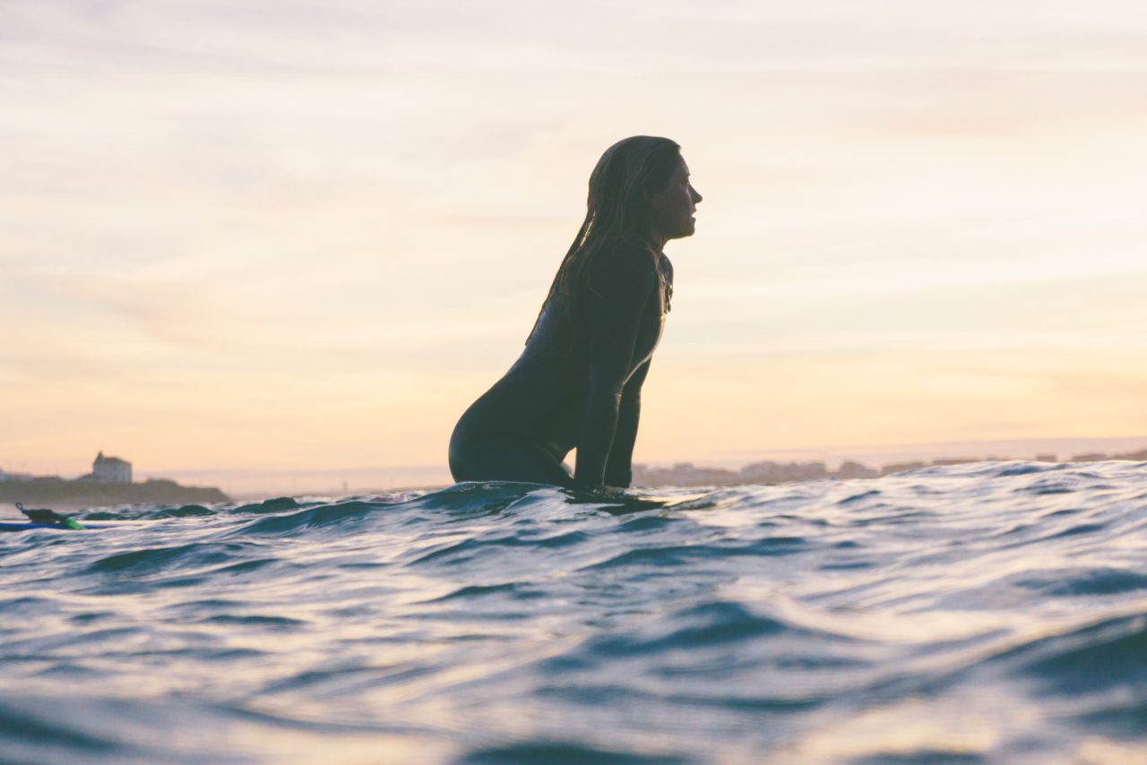 Surfista no oceano ao pôr do sol em Peniche