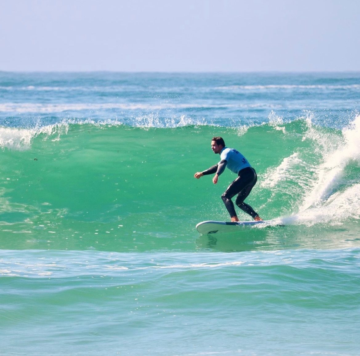 Surfer riding a softboard on a green wave